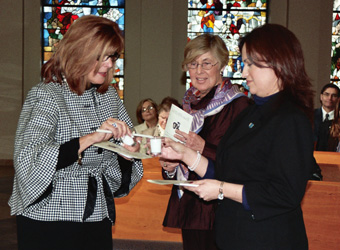 St. John’s ceremony: Dr. Joanne Robertson, SJ President, (left) lighting candle from votive held by Dr. Jennifer Miranda-Velazquez, SJ Vice President (right) with Mary Beth O’Brien, LCUSA Past President, looking on. 
